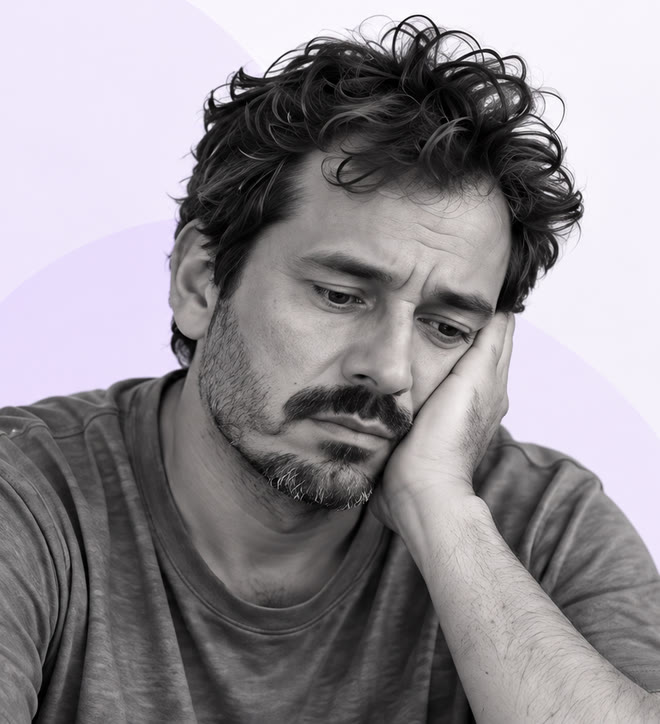 Homem com expressão cansada, apoiando o rosto na mão